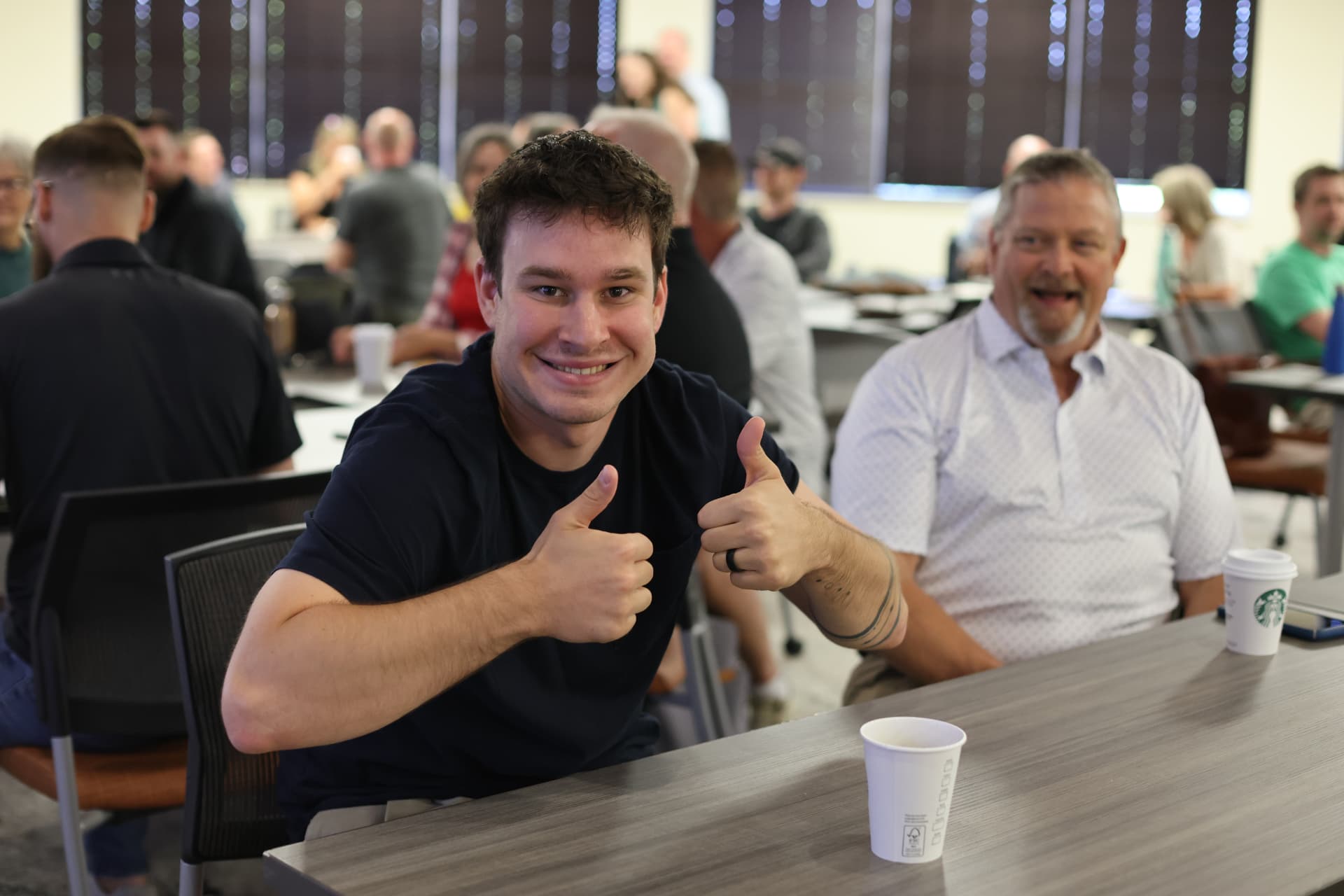 A smiling meetup attendee giving two thumbs up